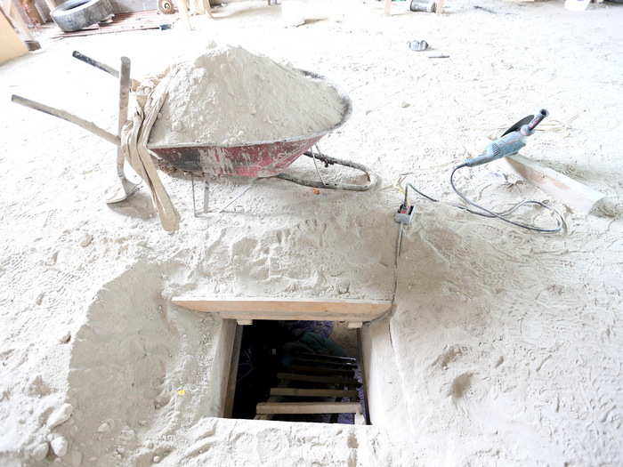 The ladder opened up to a dirt floor of a dusty unfinished home.