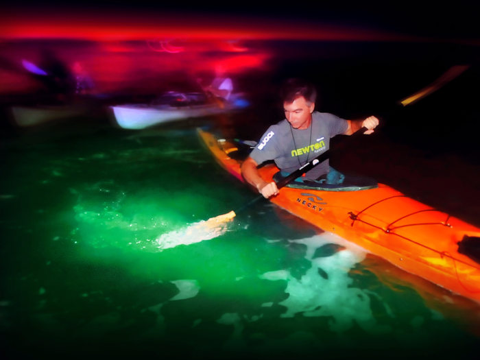 A vacationer paddles through bioluminescent phytoplankton on Florida