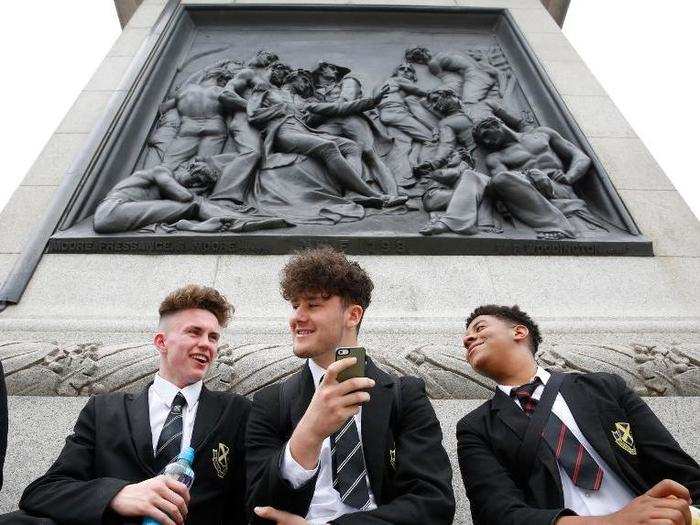 Here, Leo, Adam, and Tom — students at Finchley Catholic School in London — play "Pokémon GO" in Trafalgar Square.