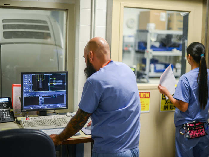 Everyone leaves the room while the X-rays fire. Raf, a radiology technician, monitors the scan. Susan Lee, an anesthesia technician, keeps an eye on Maia