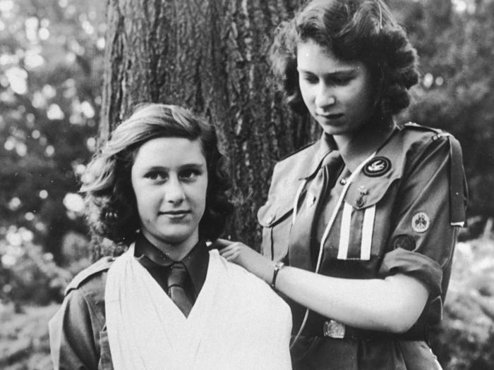 Queen Elizabeth II, right, practices bandaging with her sister, Margaret, who both joined the 1st Buckingham Palace Company of Girl Guides, in 1943. The two stripes on her uniform indicate that she