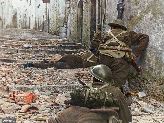 Canadian infantrymen advance up stairs while dodging sniper fire in Campochiaro, Italy in 1943.