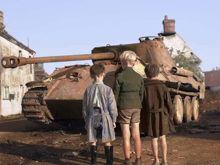 Three French boys stare at a destroyed Nazi Panther tank near Normandy, France in 1944.