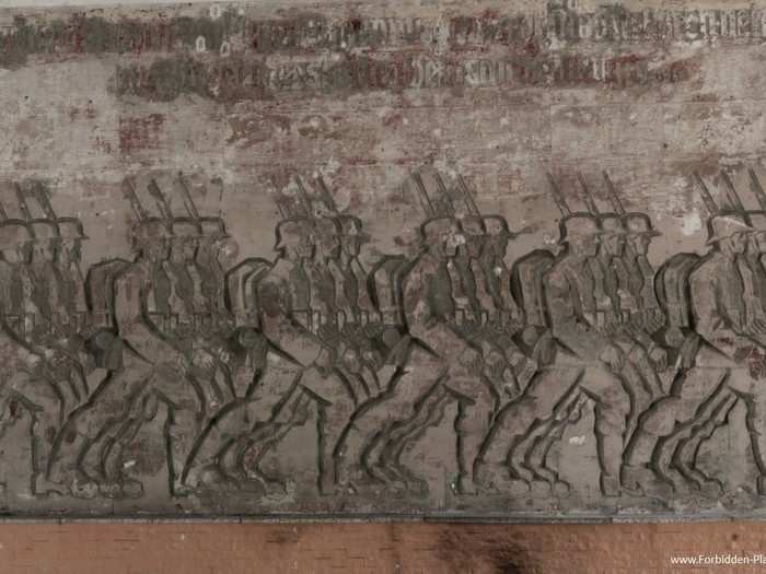 In the amphitheater, a base-relief sculpture by German artist Walter von Ruckteschell depicts German troops marching.