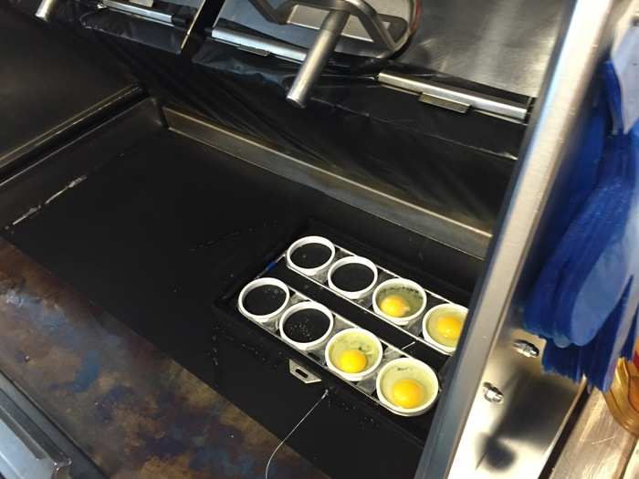 Before closing the grill, Foust breaks the yoke of every egg to make sure all the eggs cook at the same pace.