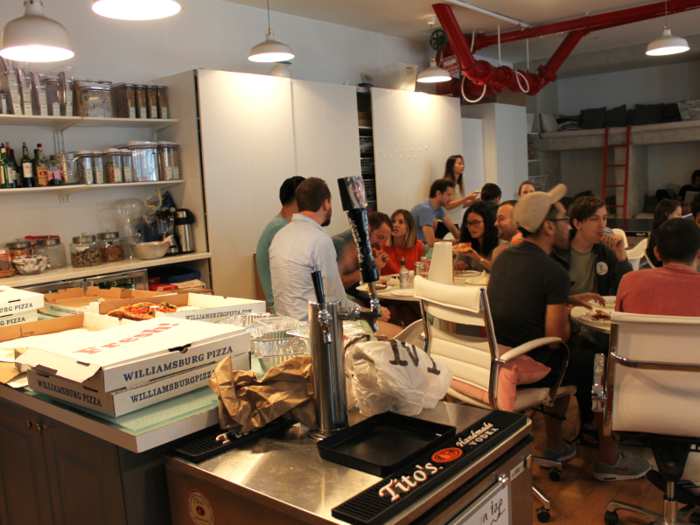 An open kitchen and dining area sits immediately to the left as you walk in, complete with an oven, rows of free snacks, and beer on tap. The day we visited, one team was treated to a pizza party — not an unusual occurrence, our guides informed us.