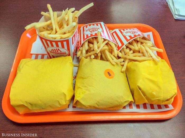 Within six minutes, my order arrives: a No. 1 Whataburger, a No. 2 Double Meat Whataburger, and an A1 Thick and Hearty Burger — all with fries, of course, plus a strawberry shake.