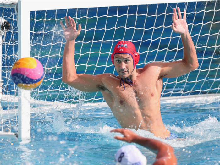 Konstantinos Flegkas blocks a shot in a preliminary water polo matchup between Greece and Japan.