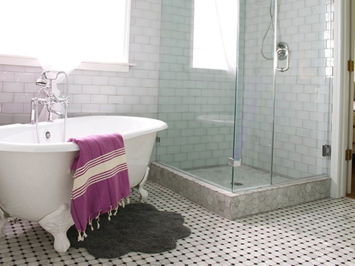 With the addition of mosaic tiles, a clawfoot bathtub, and a sleek glass shower, the bathroom looks completely different.