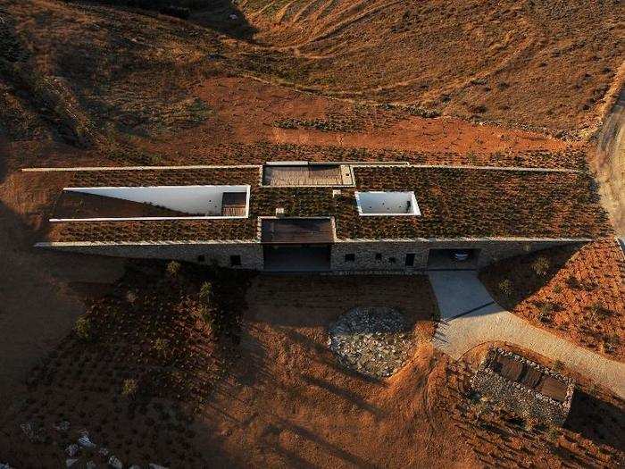 This house on the Greek island of Antiparos sits right where two slopes meet. Two long stone walls bridge the hills, allowing the house to naturally blend in the space.