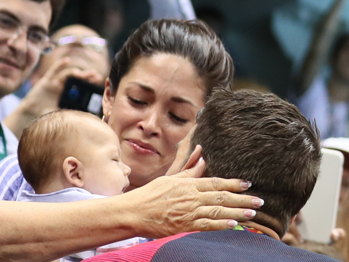 Michael Phelps celebrates winning his 20th career gold medal by kissing his three-month old son Boomer and fiancée Nicole Johnson.