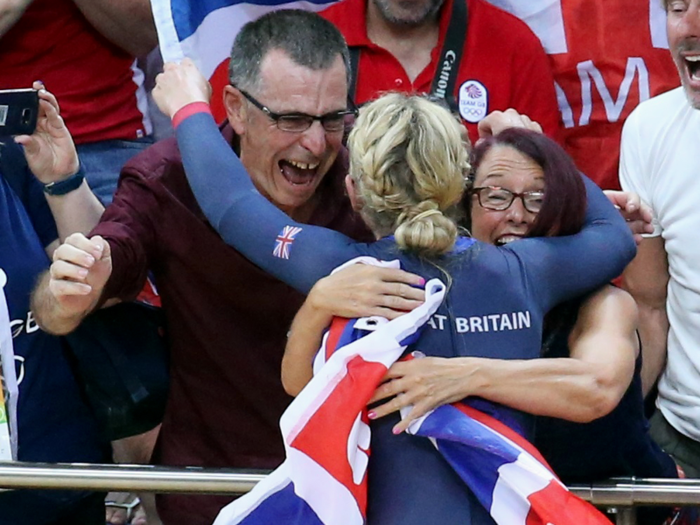 British cyclist Laura Trott hugs her parents after winning gold in women