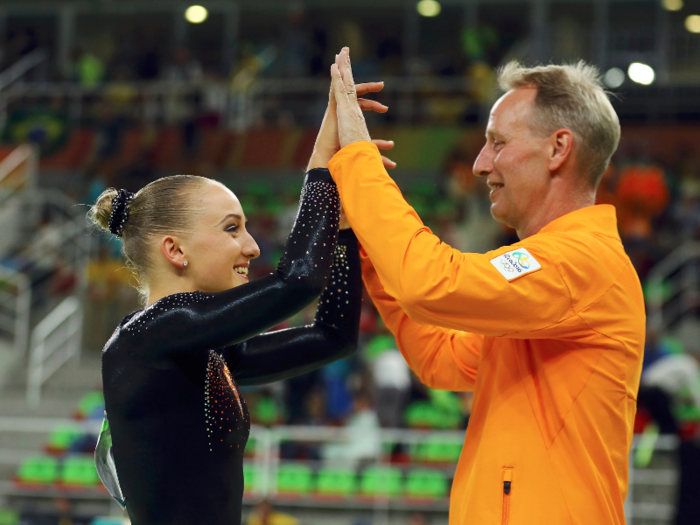 Dutch gymnast Sanne Wevers high fives her coach and father, Vincent, after besting Simone Biles and Laurie Hernandez to win gold in the women