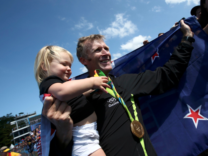 New Zealand rower Mahe Drysdale poses with his gold medal and his daughter.