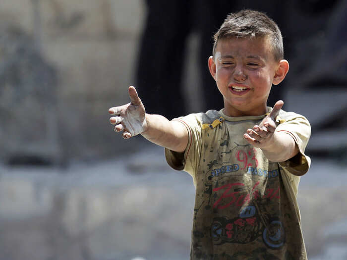 A boy whose brother was killed reacts in a rebel-held region in Syria