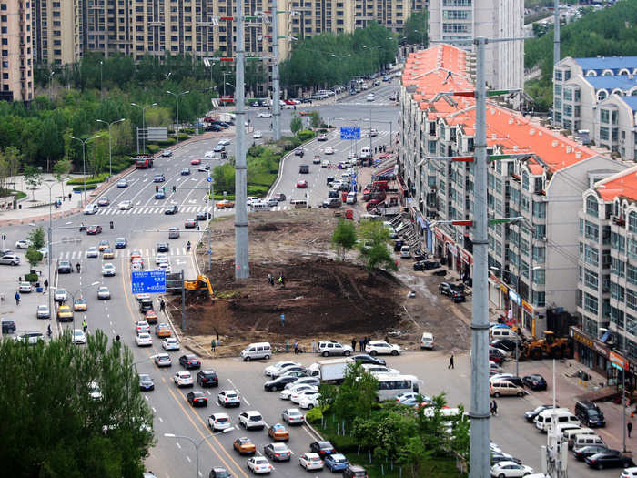 A nail house once stood in the middle of this road in the Heilongjiang Province, but it is in the process of being demolished and removed.