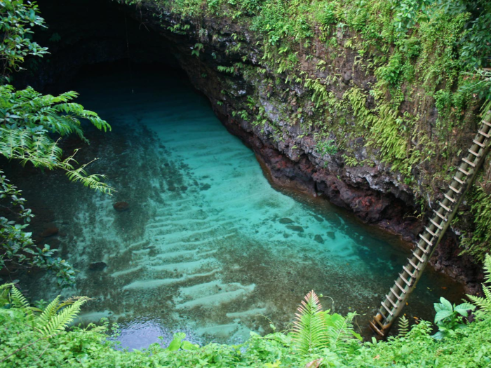 Swim in the To Sua Ocean trench, a 30-meter-deep natural seawater pool surrounded by stunning gardens in the village of Lotofaga in Samoa.