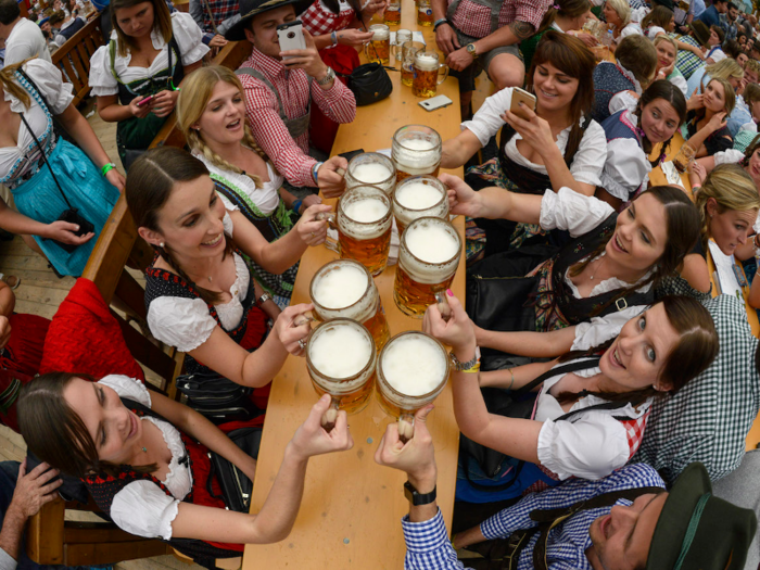 Cheers friends with massive steins of beer at Oktoberfest in Munich, Germany.