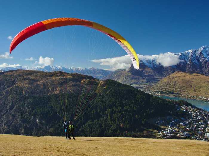 Paraglide over the mountains surrounding the picturesque city of Queenstown, New Zealand, which is known as "the adventure capital of the world."