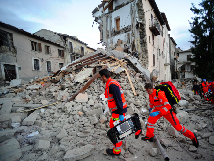 Rescuers are seen here searching a crumbled building in Arcuata del Tronto, central Italy, which is one of the many central Italy towns hit by the earthquake.