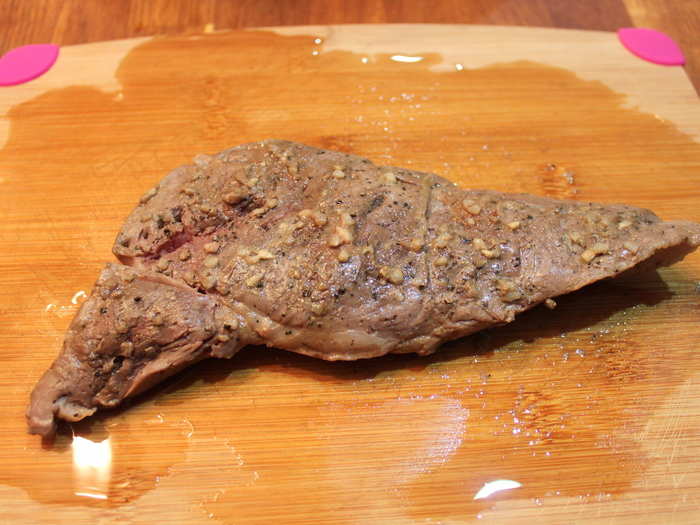 I got it out and set it on the cutting board, and the juices covered it. Slicing open part of the steak, it looked pink and finished after two hours.