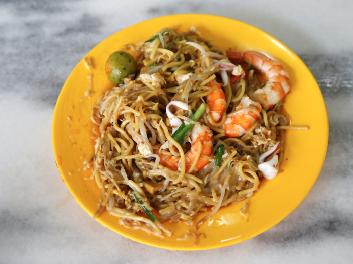 Fried Hokkien Mee is made with thick egg noodles and rice noodles which are cooked in a seafood broth and topped with shrimp, squid, pork belly, and lard. Singaporeans add chili sauce for an extra kick.