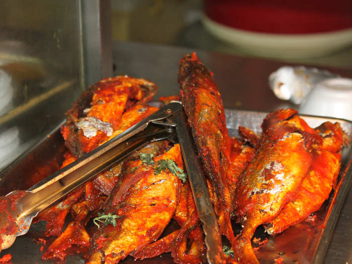 Indian food vendors sell fried fish with masala sauce.