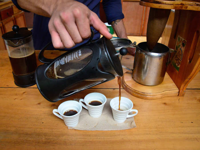 Next, he gently pressed the coffee grounds, finishing off the coffee and stopping the brewing process, and poured our brew into some sampling cups.