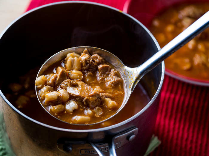 Menudo is a chili pepper broth soup made with cow stomach and hominy (dried maize kernels).