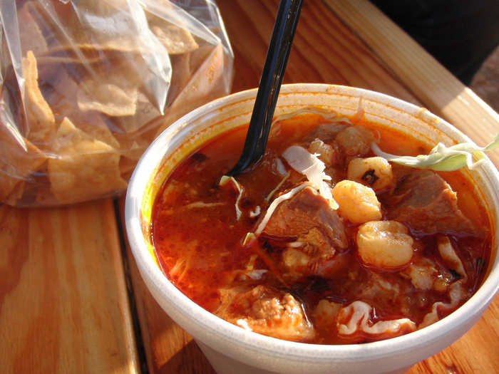 Pozole (posole) is a hominy soup made with pork, onion, and chili pepper, and topped with radishes, limes, avocado, and lettuce.