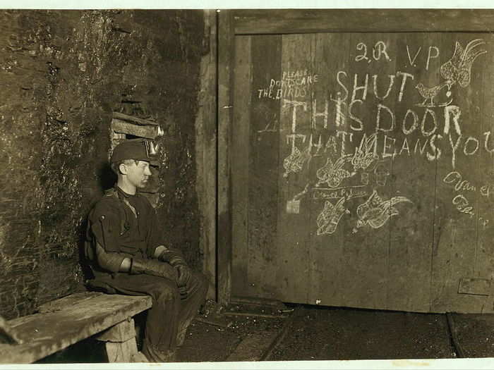 Vance, a trapper Boy, 15 years old. He had trapped for several years in a West Virginia coal mine for $0.75 a day for 10 hours work. All he does is open and shut this door: Most of the time he sits here idle, waiting for the cars to come. On account of the intense darkness in the mine, the hieroglyphics on the door were not visible until plate was developed. Taken in September 1908.