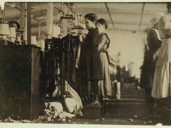 This little girl, like many others in this state, is so small she has to stand on a box to reach her machine. She is regularly employed as a knitter in a hosiery mill. Said she did not know how long she had worked there. Location: Loudon, Tennessee, December 1910.