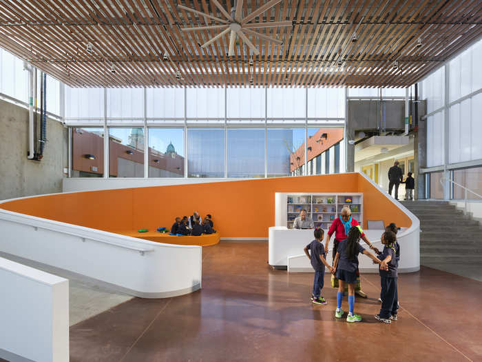 The 125,000-square-foot space has a wooden slat ceiling and large windows so that light pours in.