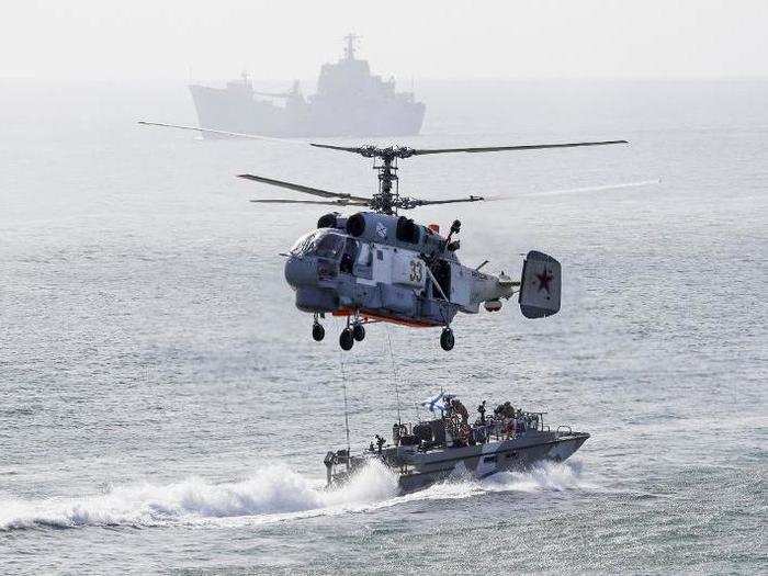 Russian helicopters and boats work in conjunction for a landing operation.