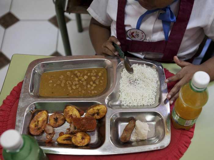 OLD HAVANA, CUBA: Rice, chicken croquette, a piece of taro root, yellow pea soup, fried plantains and an orange drink.