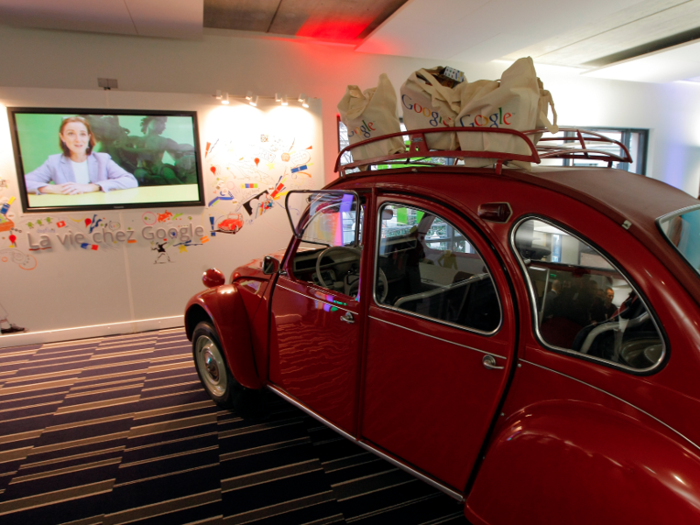 The Paris office has a shiny red Citroen 2CV car inside.