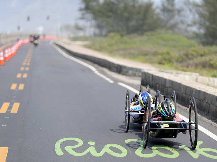 Two wheelchair racers compete in a road race.