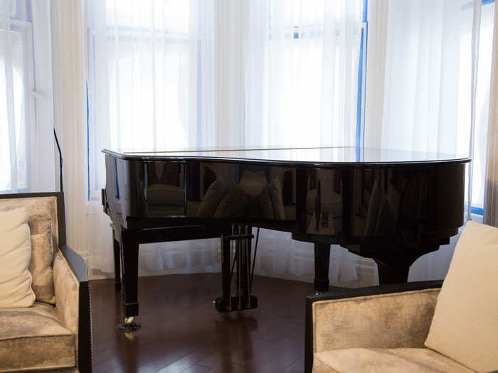 A piano sits in the corner, overlooking Alamo Square Park. The curtains hang shut to help protect the family