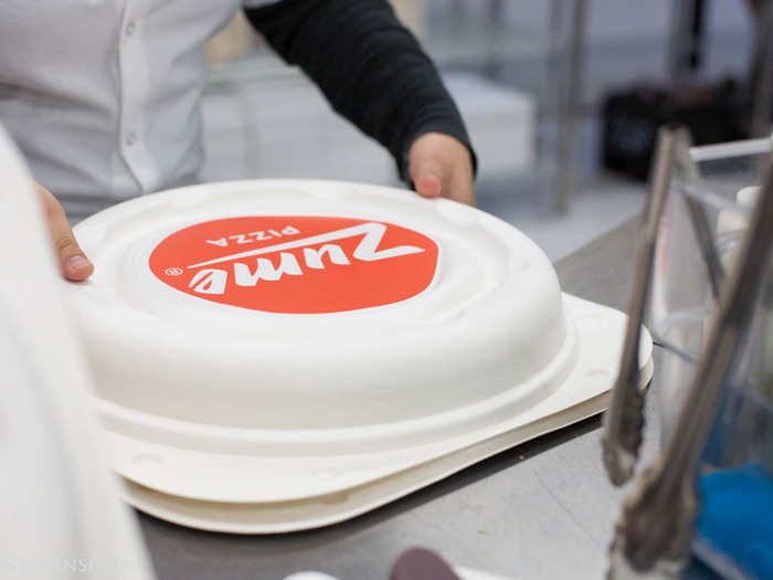 Next, a human packages the pie into a container that looks like it could be part of Elon Musk