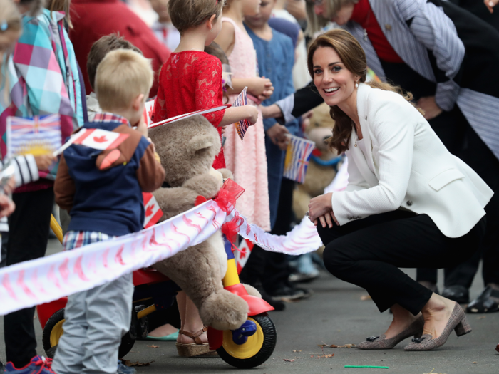 Kate opted for a simple, classic black-and-white outfit to greet local children during the final day of the trip.