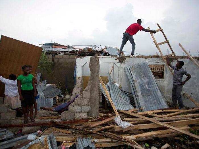 People repair their homes  in Les Cayes.