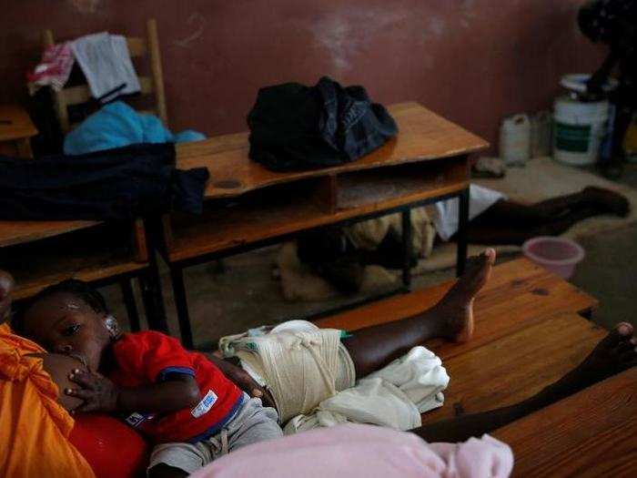 An injured woman breastfeeds her baby at a shelter.