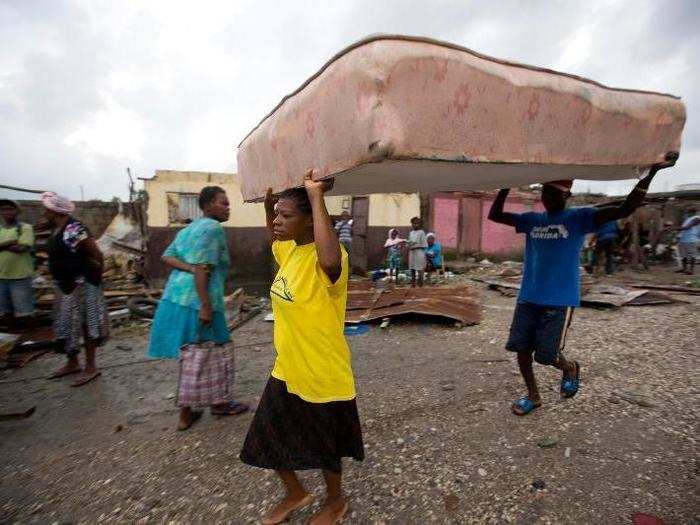 Displaced residents carry a mattress to a shelter.