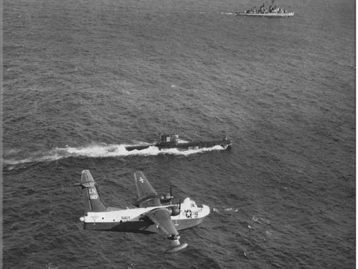 The Navy played a major role during the Cuban Missile Crisis, enforcing a blockade to prevent Soviet weapons deliveries to Cuba. This 1962 photo shows a Navy seaplane and destroyer ship shadowing a Soviet submarine.