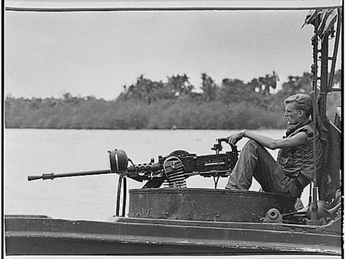 A crewman sits behind a machine gun while on patrol on the Go Cong River. Fighting in dense jungle against well-supplied Viet Cong left American troops frustrated with combat conditions. It was after this war that "Post Traumatic Stress Disorder" was officially identified.