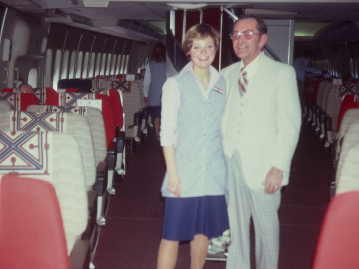 An American Airlines flight attendant poses with a first class passenger in 1978.