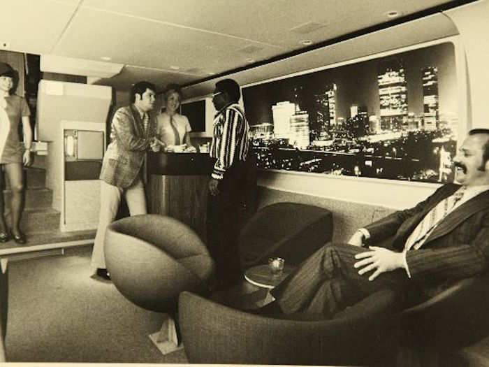 Two stewardesses attend to first class passengers in the lounge of a PSA flight.