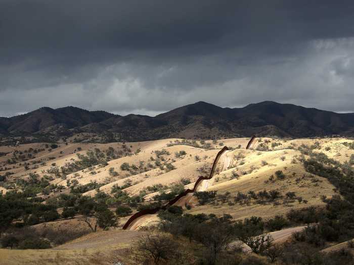 The border fence between the US and Mexico stretches into the countryside near Nogales, Arizona. According to The Atlantic, the fences and roads that mark the border end at certain points before starting again a few miles away.