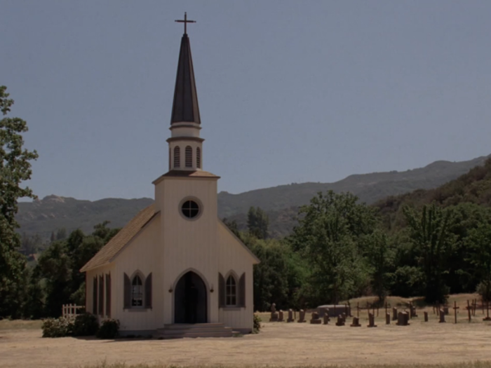 She sees a small white church with a graveyard.