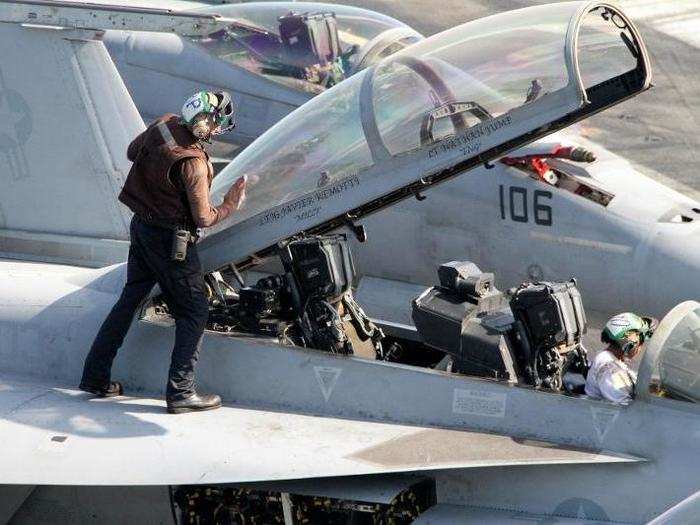 As the pilots climb out, the ground crews climb on, cleaning and inspecting all parts of the jet.